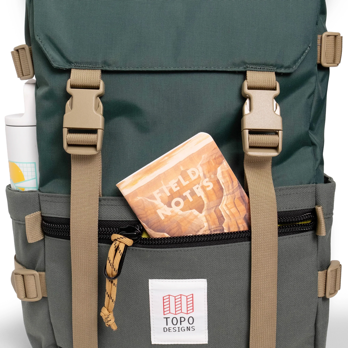 General shot Topo Designs Rover Pack Classic laptop backpack in "Forest" showing front zippered pouch and notebook.